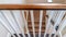 Panorama U shaped staircase with white baluster brown handrail and carpet on treads