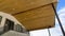 Panorama Underside of roof with brown wooden planks and round ceiling lights against sky