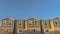 Panorama Upper storey of townhomes viewed from below against blue sky on a sunny day