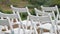 Panorama of the variety of white folding chairs in the area of marriage registration at the wedding ceremony with drops