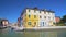 Panorama of Venice canal and cozy colorful houses, tourists walking in Burano