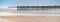 Panorama of vertical wooden planks in the sand of an unfinished wooden dock at the beach in France