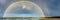 Panorama view across Mystics Beach, Killalea, NSW of double rainbow