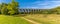 A panorama view across a park towards the Chappel Viaduct near Colchester, UK