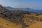A panorama view across the volcanic island of Nea Kameni, Santorini with the Thirasia Island in the background