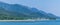 A panorama view along the forested shoreline in the Gastineau Channel towards Juneau, Alaska
