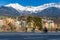 Panorama view of colorful buildings and mountains across from the flowing river of Innsbruck, Austria