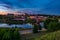 Panorama view on evening in old town on the bank of wide river with evening fluffy curly rolling cirrostratus clouds and blue