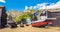 A panorama view of fishing boats pulled onto the shingle rest between net drying sheds on the beach at Hastings, Sussex, UK