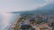 Panorama view flight over beach. Aerial drone footage of a seascape. Palm trees, sand, beach umbrellas. Vacation