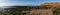 Panorama view of golden evening light reflectiing in tidal pools on a rocky beach with the ocean behind