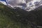 panorama with view of a green gorge in the mountains with a cloudy sky