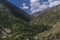 panorama with view of a green gorge in the mountains with a cloudy sky