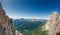 Panorama view of a group of mountain climbers on a steep Via Ferrata with a grandiose view of the Italian Dolomites