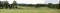 Panorama view of a landscape, golf club, park for visitors, trees, road and cloudy sky