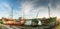 Panorama view of old fishing boat wrecks stranded on a rocky beach at sunset