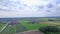 Panorama view over the green grass meadows, agricultural land and greenhouses.