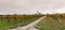 Panorama view of a picturesque white country church surrounded by golden vineyard pinot noir grapevine landscape with a country ro