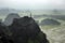 Panorama view of rice fields, rocks and mountaintop pagoda