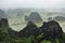 Panorama view of rice fields, rocks and mountaintop pagoda from