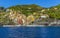 A panorama view from the sea across the harbour breakwater looking up the main street of the Cinque Terre village of Riomaggiore