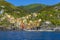A panorama view from the sea across the harbour breakwater towards the Cinque Terre village of Riomaggiore, Italy