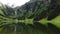 Panorama view to a mountain lake and a large waterfall with sound of the bells from the cows