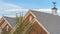 Panorama Weather vane and vent on top of the gray gable roof of home against blue sky