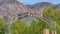 Panorama Welcome arch in Ogden Utah against lush trees towering mountain and blue sky