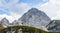 Panorama of western wall of Mount Mangart with Hikers in the Julian Alps. Shoot from Mangart Saddle, Mangartsko sedlo. Border of