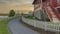 Panorama Whispy white clouds Curved asphalt pathway at the front of a fenced house at Daybrea