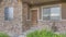 Panorama Whispy white clouds Exterior of a house with stone veneer wall and wooden door with