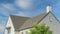 Panorama Whispy white clouds Home exterior with asphalt composite shingle roof and chimney