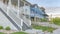 Panorama Whispy white clouds Three large houses with white picket fence and verandas at the entrance in Daybreak, Utah