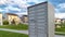 Panorama White metal cluster mailbox with pond grassy terrain and homes in the background