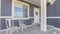 Panorama White porch chairs against window and front door of home with gray exterior wall