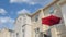 Panorama White puffy clouds Red umbrella on a balcony of a townhouse with cream wall exterio