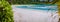 Panorama of white sandy tropical beach and blue lagoon on sunny lazy day. Vacation holidays concept. Heavenly place