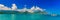 Panoramia of tropical lagoon, lush mountains, a catamaran and th