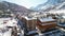 Panoramic aerial drone scenic view at ski slopes, mountain skiing and popular resort town. Italian ski resort in Alps in