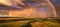 Panoramic, aerial photo of dramatic rainbow over european landscape. Large late evening rainbow over city and hills in