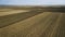 Panoramic aerial view of agricultural cultivated field with tractor performing fall tillage