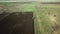 Panoramic aerial view of agricultural cultivated field with tractor performing fall tillage