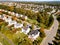 Panoramic aerial view of a cluster of houses with a road taken by a drone during the golden hour