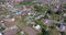 panoramic aerial view and flight over eco village with wooden houses, gravel road, gardens and orchards