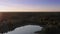 Panoramic aerial view of the forest lake and endless woodland at sunset