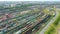 Panoramic aerial view of a large sorting marshalling yard railway station with many freight trains against the backdrop of the urb