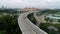 Panoramic aerial view of river bridge in the city with trees in parks. Shot. Aearial view of the bridge with cars
