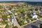 panoramic aerial view of small provincial town or big eco village with wooden houses, gravel road, gardens and orchards