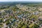 panoramic aerial view of small provincial town or big eco village with wooden houses, gravel road, gardens and orchards